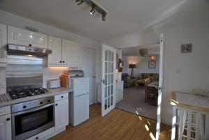 a kitchen with white appliances and a living room at Calabeinn in Anstruther