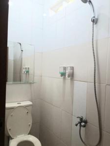 a bathroom with a shower with a toilet and a mirror at Womy Homy in Bogor