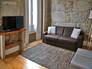- un salon avec un canapé et une télévision dans l'établissement Citybreak-apartments Bolhao, à Porto