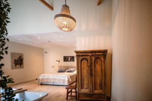 een slaapkamer met een bed en een kroonluchter bij B&B de Sfeerhoeve in Beilen