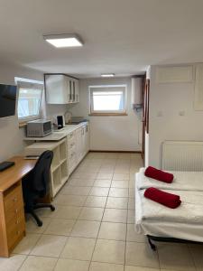 a room with two beds and a desk and a kitchen at Pokoje Kochanowskiego in Sopot