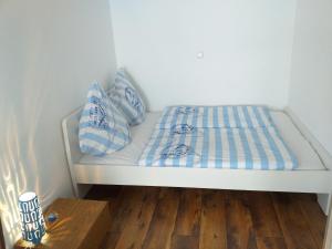 un letto con cuscini blu e bianchi e un pavimento in legno di Ferienwohnung 211 a Timmendorfer Strand