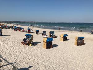una spiaggia con sedie e ombrelloni sulla sabbia di Ferienwohnung 211 a Timmendorfer Strand