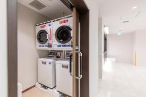 a laundry room with two washer and dryers at Hotel Sanrriott Osaka Hommachi in Osaka