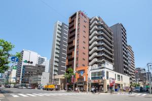 un grand bâtiment dans une rue de la ville avec des bâtiments dans l'établissement Hotel Sanrriott Osaka Hommachi, à Osaka