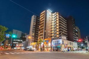 a tall building on a city street at night at Hotel Sanrriott Osaka Hommachi in Osaka