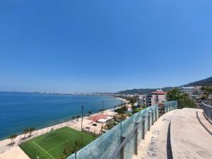 una vista sulla spiaggia dal balcone di un edificio di Redsun Apartment a Vlorë