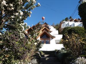 a stairway leading up to a white building with trees at Miralago I in San Carlos de Bariloche