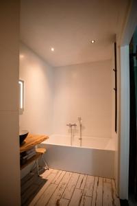 a bath tub in a bathroom with a wooden floor at B&B de Sfeerhoeve in Beilen
