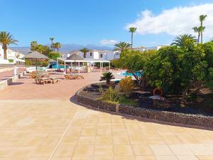 ein Resort mit einem Pool, Tischen und Palmen in der Unterkunft Villa Sabina in San Miguel de Abona