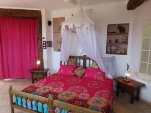 APARTAMENTO LUCERO beach campello في أليكانتي: غرفة نوم بسرير احمر مع مظلة