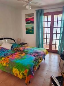 ein Schlafzimmer mit einem Bett mit einer bunten Decke in der Unterkunft Villa Sabina in San Miguel de Abona