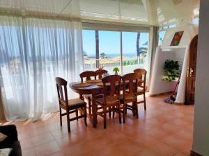 a dining room with a table and chairs and a balcony at Villa Sabina in San Miguel de Abona