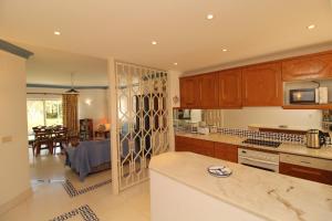 una cucina con armadi in legno e una sala da pranzo di SÃO RAFAEL BEACH VILLAGE 131 - Apartamento T2 Praia de São Rafael - Albufeira ad Albufeira