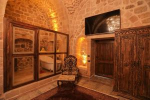 Habitación con baño con bañera y TV. en Ankahan Konağı, en Mardin