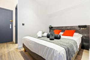a bedroom with a bed with orange and white pillows at WELCS ESTUDIO 070 EMP frente al Mar in Empuriabrava