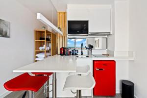 a kitchen with a red refrigerator and white cabinets at WELCS ESTUDIO 070 EMP frente al Mar in Empuriabrava