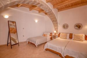 2 camas en una habitación con un arco en Traditional cottage near Kissamos and Falassarna 2 feel like home properties, en Áyios Vasílios