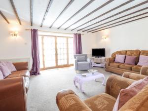 a living room with couches and a table at Y Wennol in Llangefni