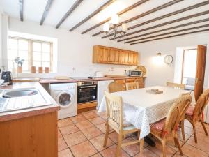a kitchen with a table and a table and chairs at Y Wennol in Llangefni