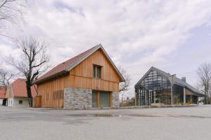 eine große Holzscheune und ein Glasgebäude in der Unterkunft PIRA HOTEL in Postojna