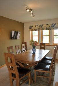 a dining room with a wooden table and chairs at Faolin- superb detached family villa East Neuk in Anstruther