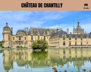 a large building with a lake in front of it at La Perle de Laigneville - Idéal pro - Netflix - Proche Parc Astérix & Chantilly - Parking public gratuit - Wifi in Laigneville