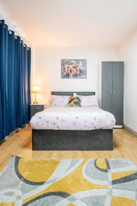 a bedroom with a bed with blue curtains and a rug at Birmingham City Centre Apartment room near China Town in Birmingham