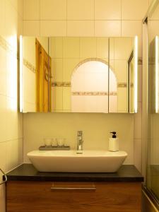 ein Bad mit einem Waschbecken und einem Spiegel in der Unterkunft Ferienwohnung Mühlmann in Außervillgraten