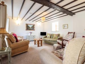 a living room with a couch and chairs and a table at Y Fran in Llangefni