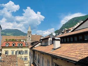 a view of a city with roofs and a church at Lauben Suite Old Town Bolzano in Bolzano