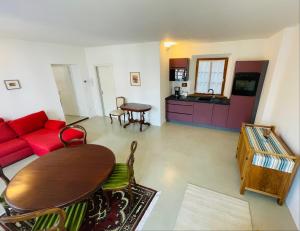 - un salon avec un canapé rouge et une table dans l'établissement Lauben Suite Old Town Bolzano, à Bolzano