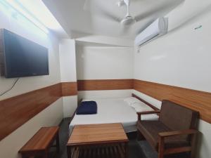 a small room with a bed and a chair and a tv at Hotel Shahin(residential) in Dhaka