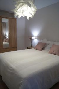 Un dormitorio con una gran cama blanca y una lámpara de araña. en EASY RENT Apartments- Kazimierz Dolny Doły 4 lok 4 en Kazimierz Dolny