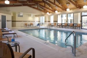 a large indoor pool with chairs and a table at Courtyard by Marriott Anchorage Airport in Anchorage