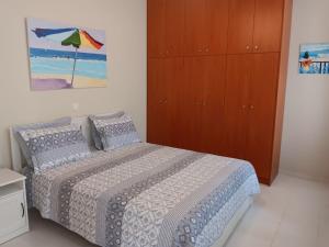 a bedroom with a bed and a wooden cabinet at Giulias beach house in Theologos