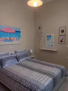 a bedroom with a bed with a blue comforter and an umbrella at Giulias beach house in Theologos