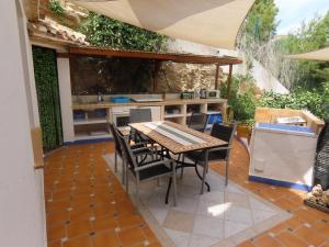 a patio with a table and chairs and an outdoor kitchen at APARTAMENTO LUCERO beach campello in Alicante