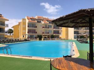 a large swimming pool in front of a building at Spacious 2 bed Apt with pool & sea views in Sal Rei