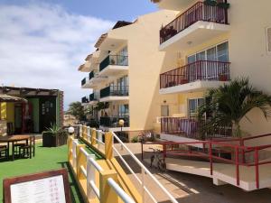 a building with balconies and tables and a table at Spacious 2 bed Apt with pool & sea views in Sal Rei