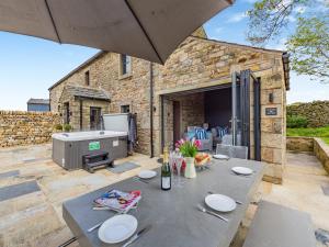 a patio with a table and a grill in front of a building at Holme House in Eldroth