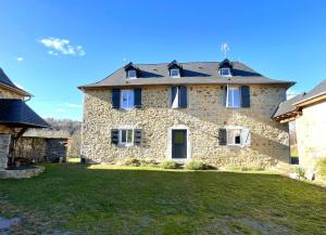 een groot stenen huis met een grasveld bij Le gout in Lasseubetat