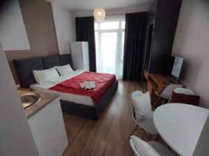 um quarto com uma cama com um cobertor vermelho e um lavatório em Cozy Studio Swimming Pool And Jacuzzi em Batumi mais 10 fotografias