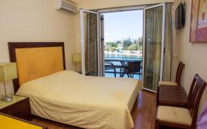 1 dormitorio con cama y vistas a un balcón en Hotel Lefkadi, en Lefkandi Chalkidas
