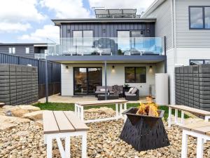 a house with a fire pit in front of it at Luxury 5 Bedroom Home - Sentinel Chalet - Snowy Mountains - Jindabyne in Jindabyne