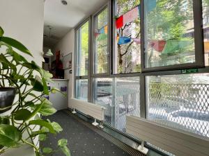 um quarto com janelas com um banco à frente em Himalayan Hostel em Zagreb