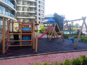um parque infantil com dois baloiços e um escorrega em Cozy Studio Swimming Pool And Jacuzzi em Batumi
