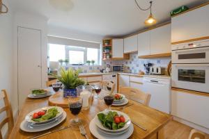 a kitchen with a wooden table with plates of food at 54 Linden Road in Aldeburgh