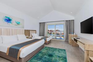 a hotel room with two beds and a flat screen tv at Pickalbatros Jungle Aqua Park - Neverland Hurghada in Hurghada