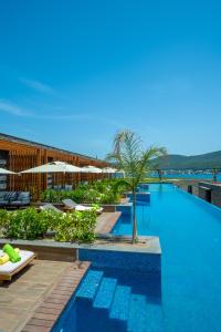 a pool at a resort with chairs and trees at La Blanche Island Bodrum in Guvercinlik